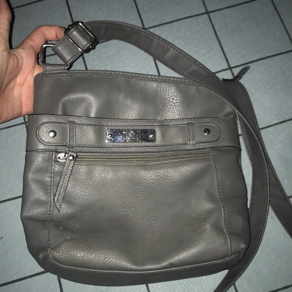 Grey shoulder strap over purse